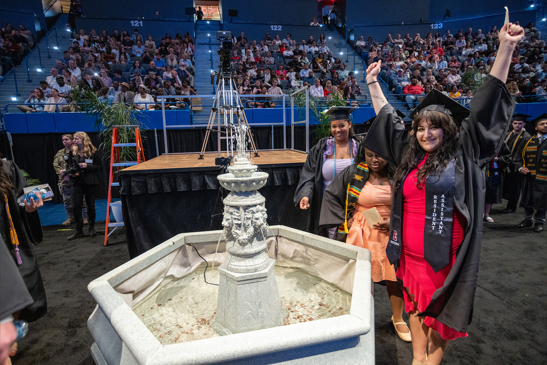 Graduates posing for a photo by the Make a Wish fountain