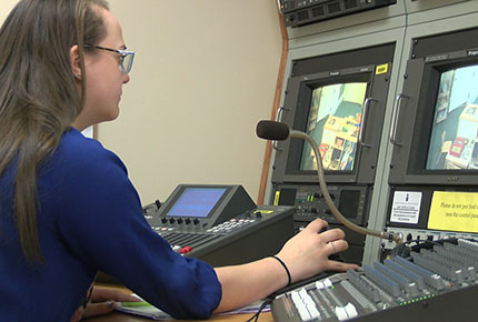 Student in video control room recording children's play 