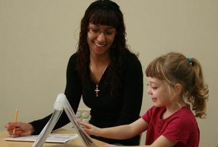Researcher giving literacy assessment to preschooler