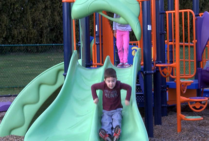 A child slides on a slide.