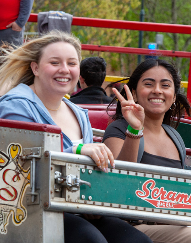 student on carnival ride giving a peace sign