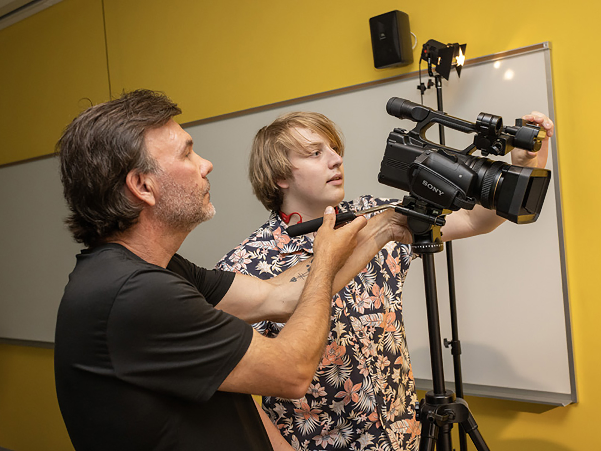 Brian Day and a student adjusting a camera