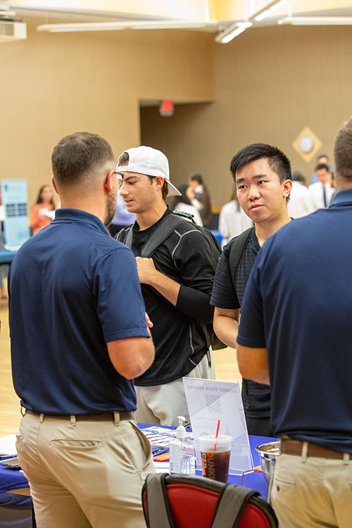 A student networks with a prospective employer at Accounting Fair