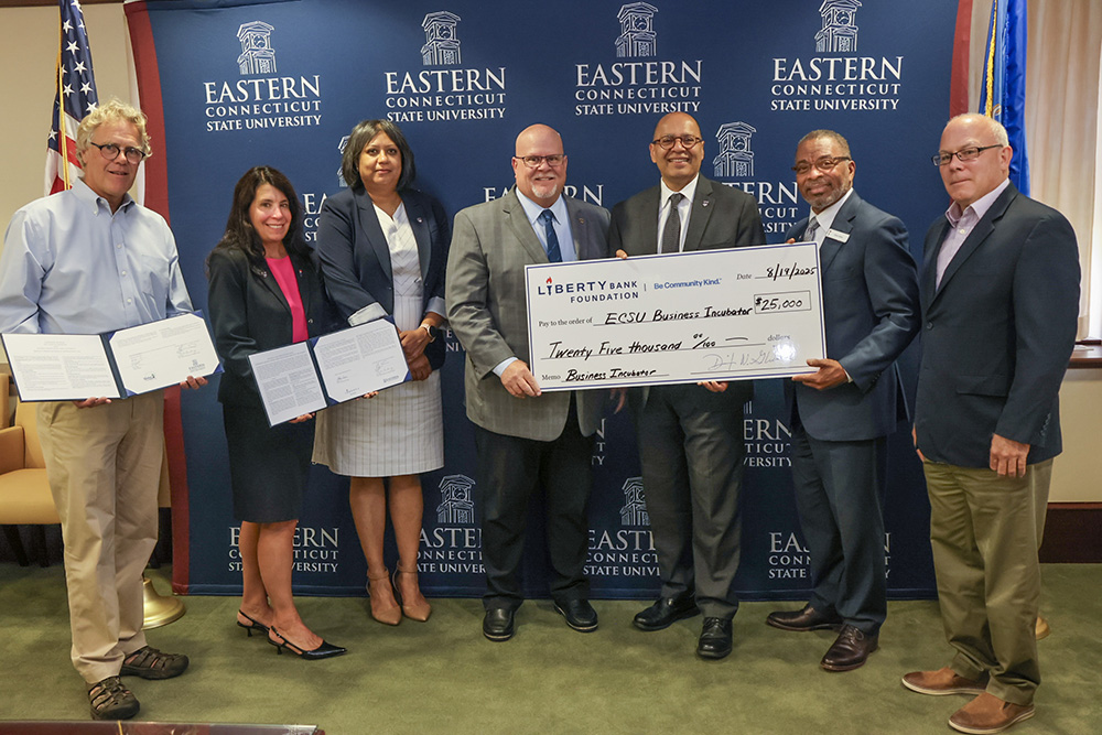 From left: Windham Mayor Tom DeVivo, Liberty Bank Vice President of Community Development Pamela Days-Luketich, Dean Niti Pandey, Interim Chief Development Officer Philip Ellmore, President Karim Ismaili, Liberty Bank Vice President of Community Development Glenn Davis, and Windham Town Manager Rob Zarnetske display Eastern's donation from the Liberty Bank Foundation.