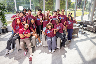 Residential Life Coordinator Emmanual Augustin poses with a cluster of students