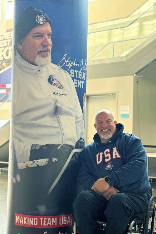 Steve Emt '03 in front of a banner of himself.