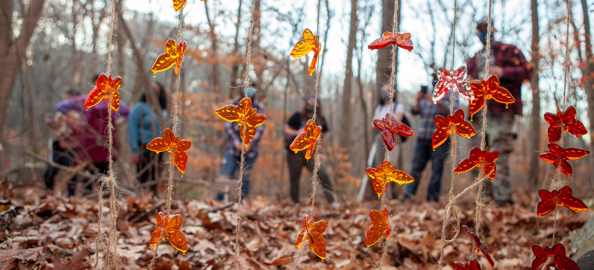 Orange plastic butterflies on string with students in the background