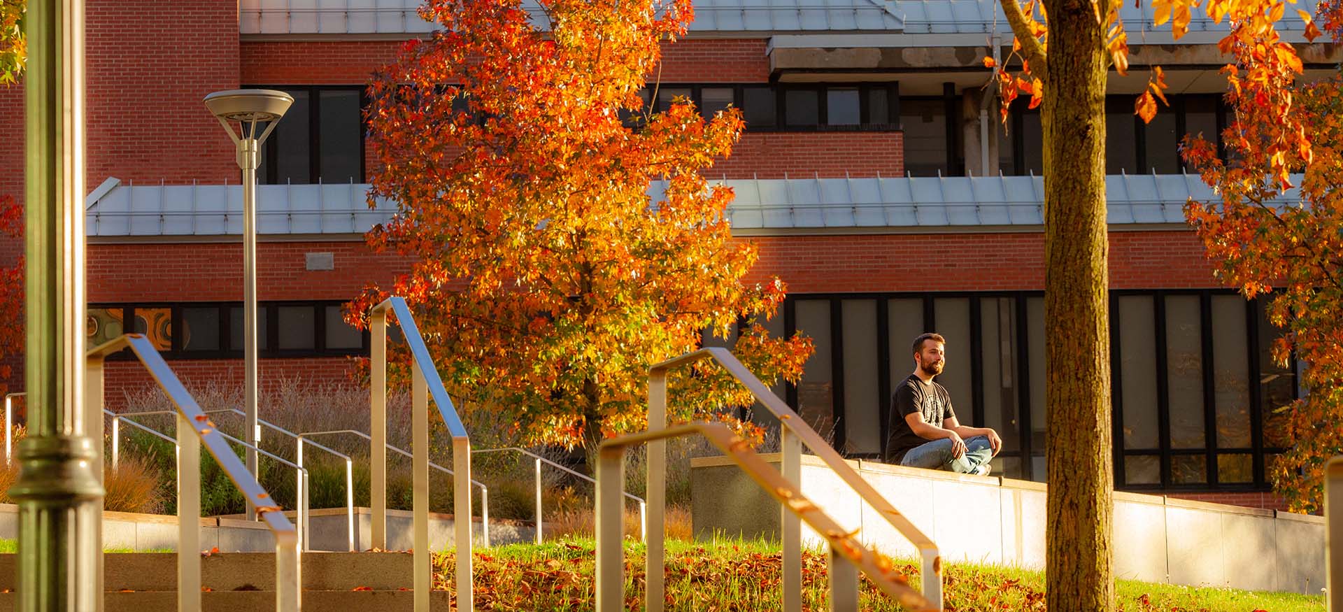 student enjoying the view surrounded by fall foliage