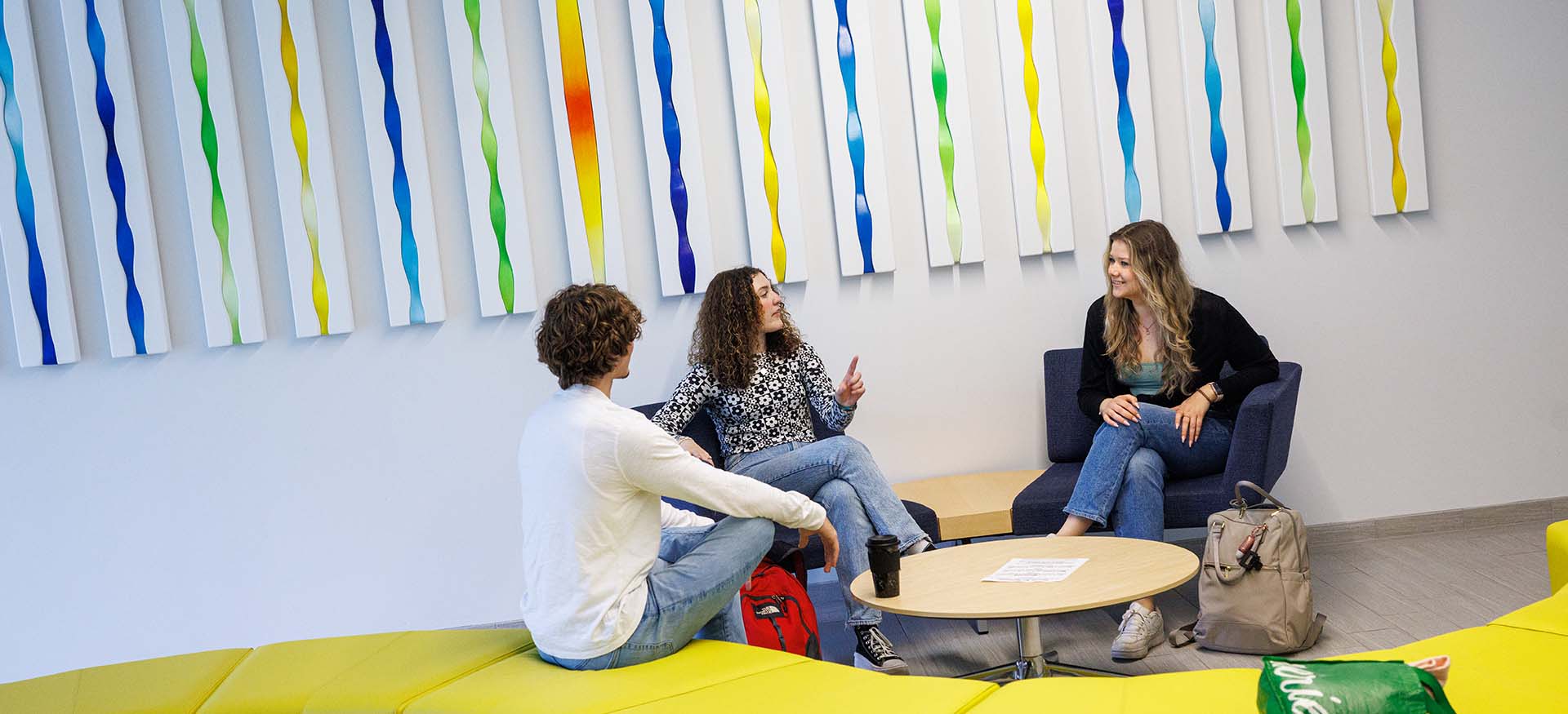 students chatting in front of decorative wall art