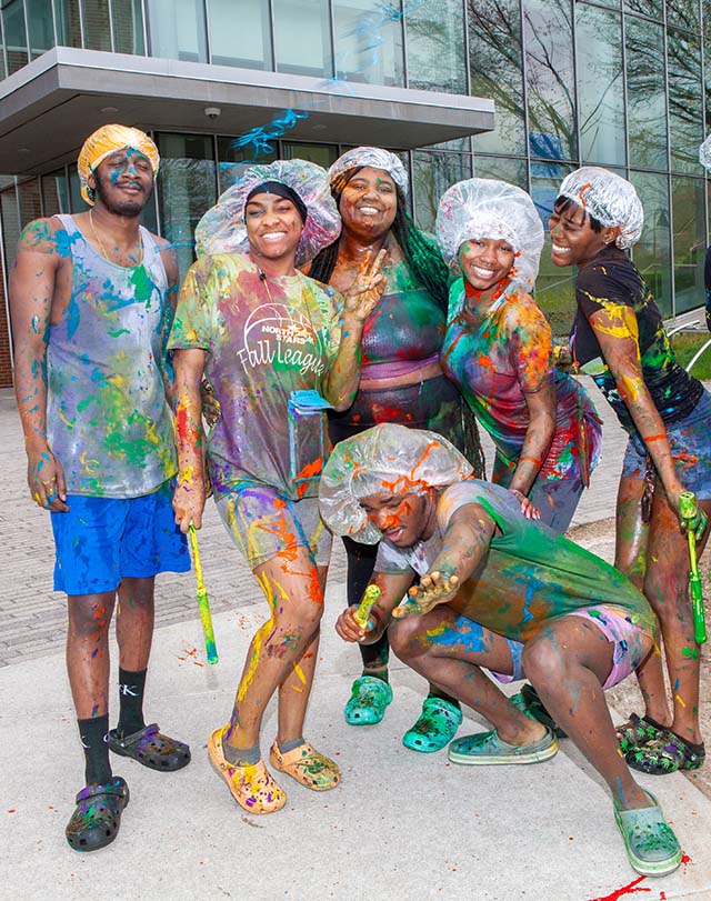 students posing for a photo covered in paint
