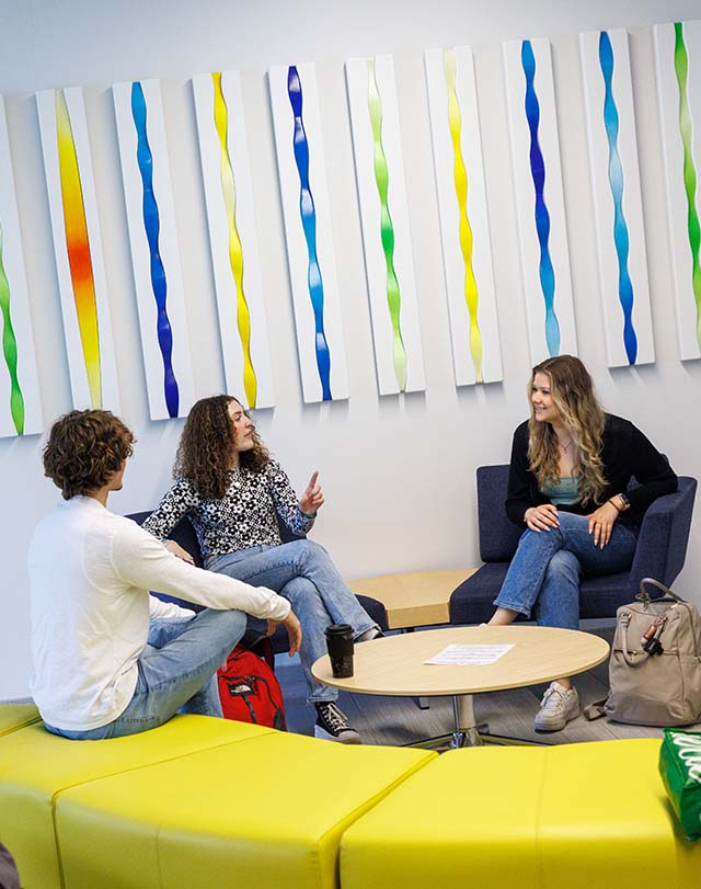 students chatting in front of decorative wall art