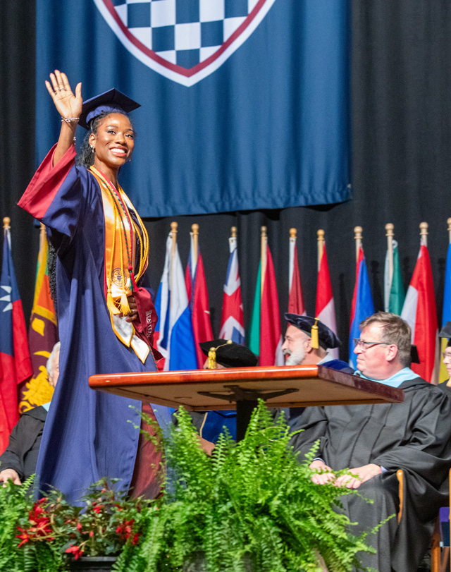 graduate waving from Eastern's commencement ceremony