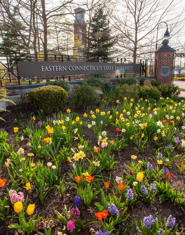 the Eastern Connecticut State University entrance with blooming flowers in the foreground