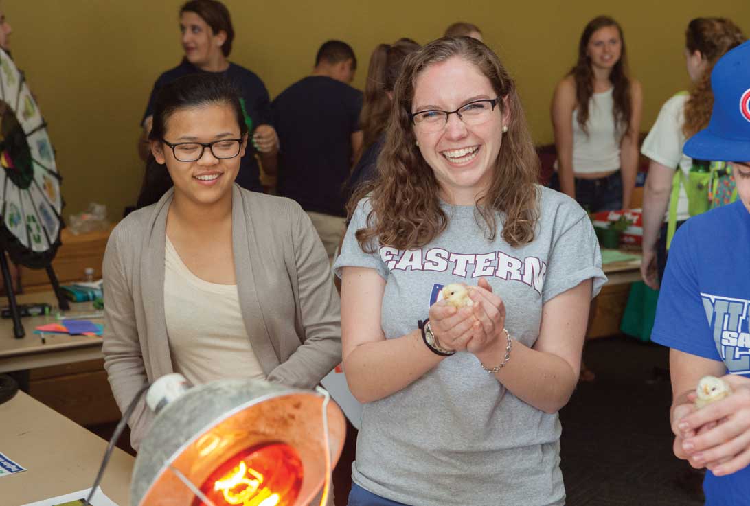 two students holding baby chicks