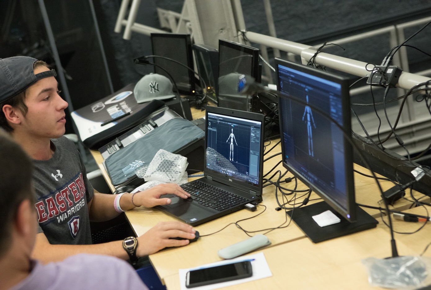 two students using a computer with motion capture software on the screen