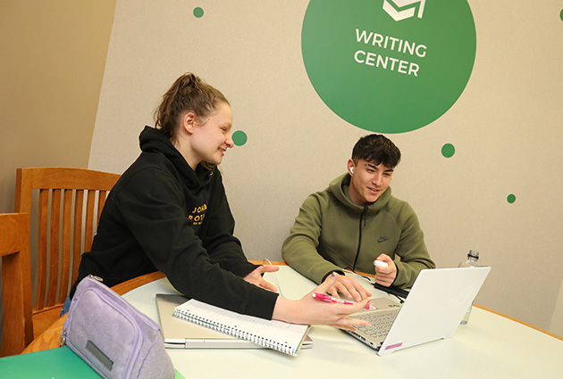 students working on laptop in Writing Center