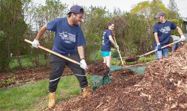 Students shoveling mulch for community service