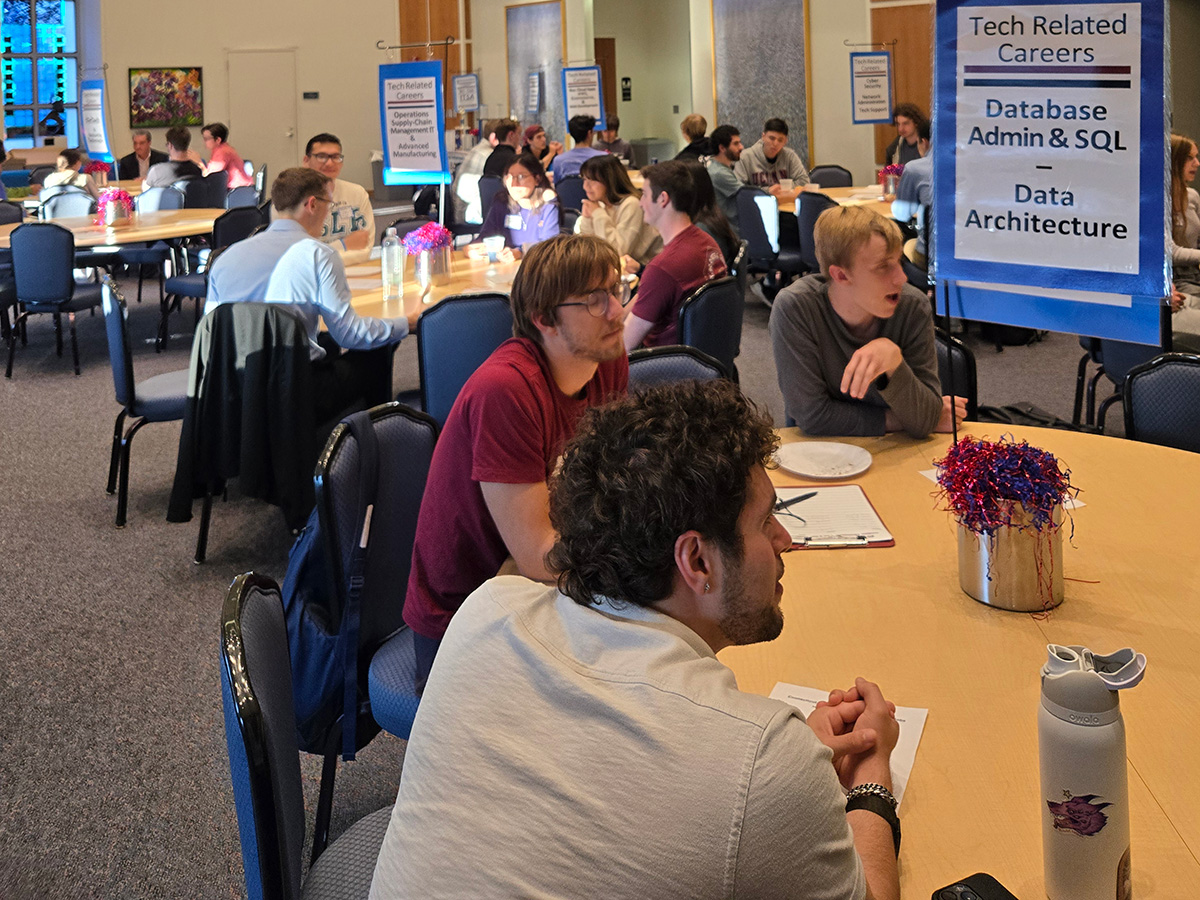students sitting at a table with a sign that reads 'Tech Related Careers Database Admin & SQL - Data Architechure' on it