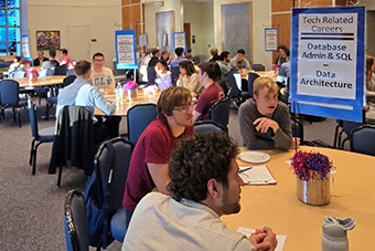  students sitting around a table talking 