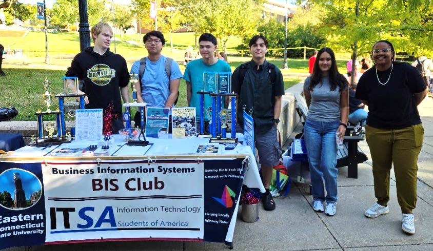 students standing around a BIS Club table at the student club fair