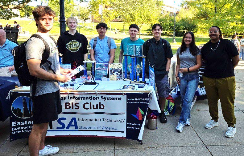 students standing around a BIS Club table at the student club fair