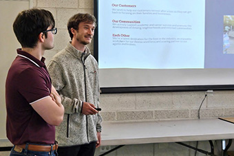  students giving a presentation in from of a projection 