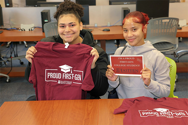 students holding a shirt and sign that read "Proud First-Gen college student"