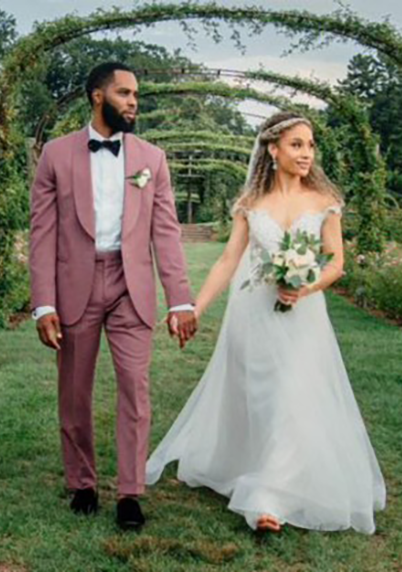 The Warrens wedding photo holding hands in a grassy area