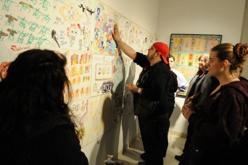 people drawing on the walls of Akus Gallery