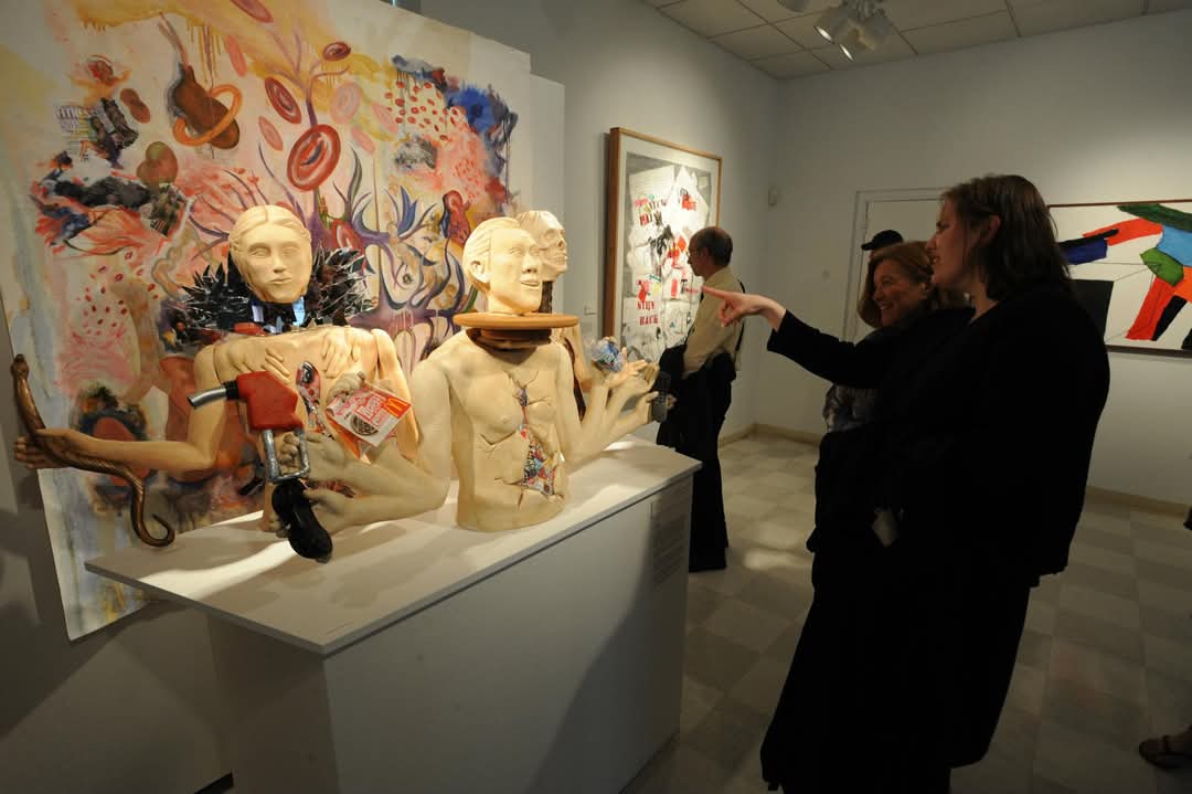 people discussing artwork at the Student Exhibition