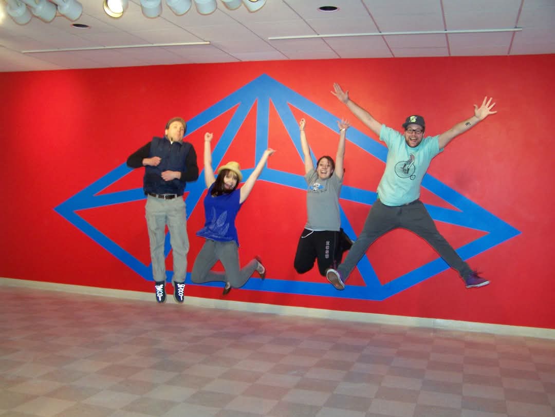 students leaping in front of a Sol deWitt artwork