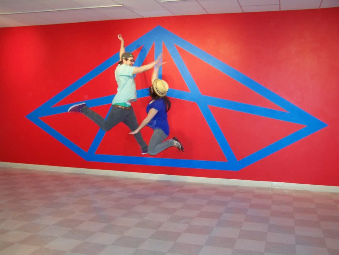 students leaping in front of a Sol deWitt artwork