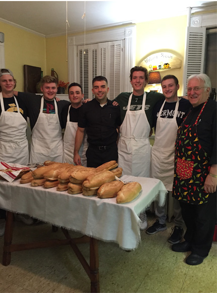 Students and Priests preparing the bread table for pasta dinner