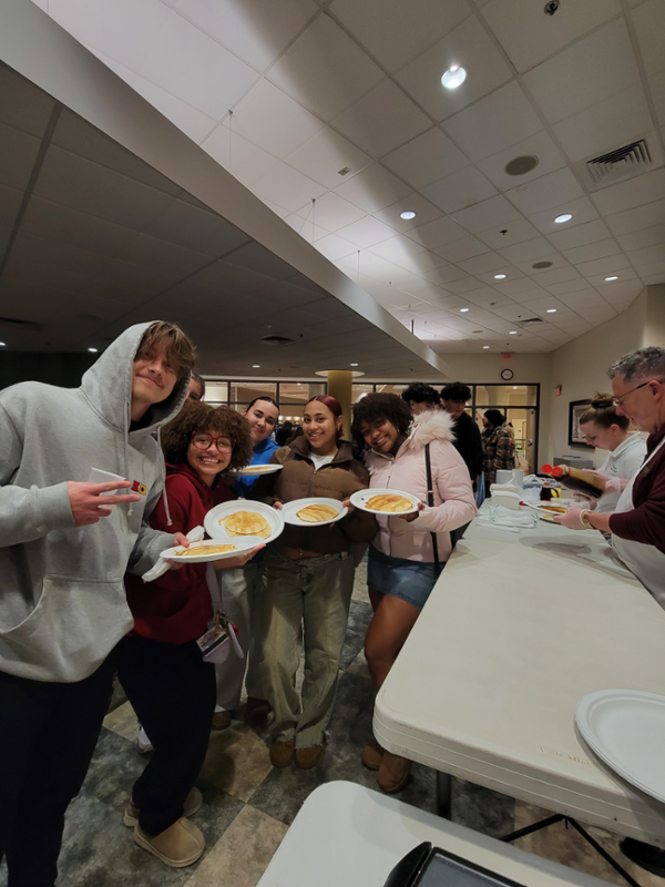 Students pose at Thursday Knight Cafe with their pancakes and large smiles.