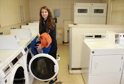 student loading a washing machine