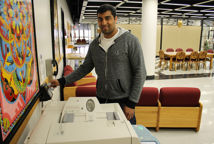 student sliding their card through a card reader