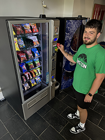 student swiping their card in a vending machine card reader