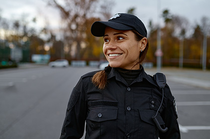 smiling police woman standing in a parking area