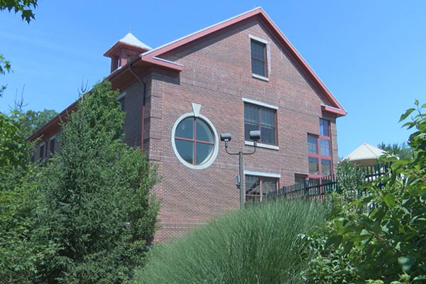 Exterior side view of the CECE red brick, 3-story building