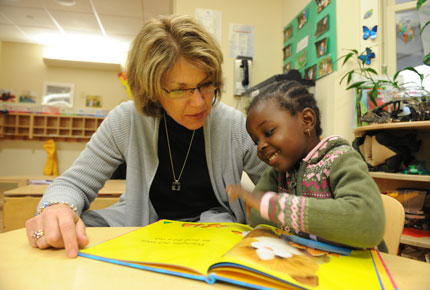 Adult reads a picture book to a preschooler