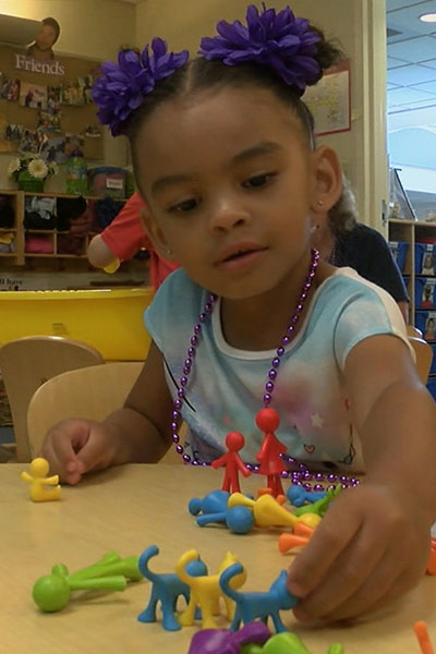  A young girl plays with the plastic replica family.  