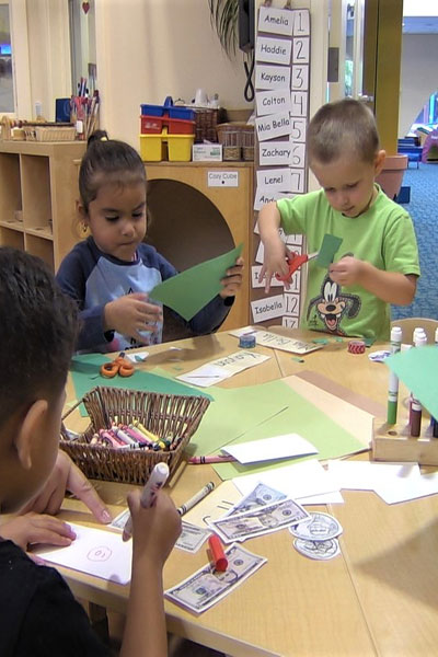  Children use paper, markers, and scissors to create money. 