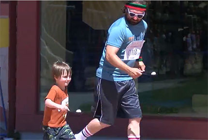 A child and his teacher run while carrying plastic eggs on a spoon