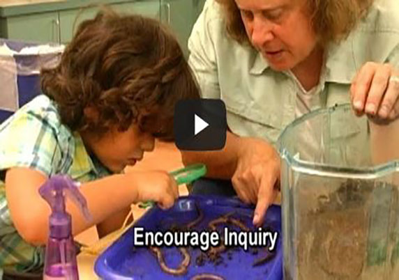 A teacher and child look at worms together. 