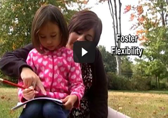 A teacher reads to a child outdoors.