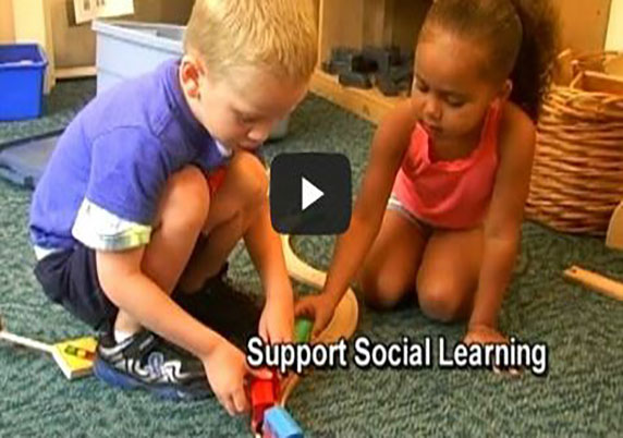 Two children play with trains and tracks together.