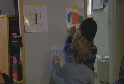 Children using tangrams on a wipeboard.