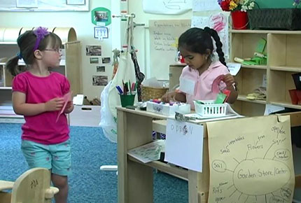 Children pretend play that they are in a garden center.