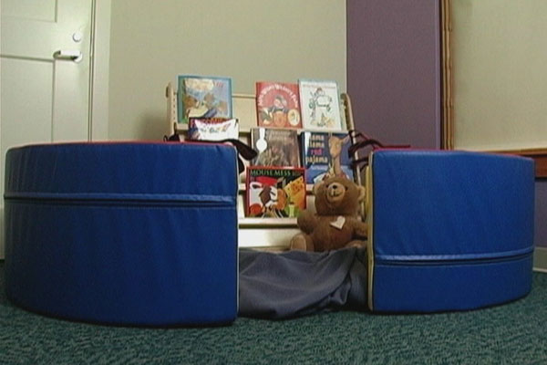 Image of two cushions and some books in a preschool classroom.