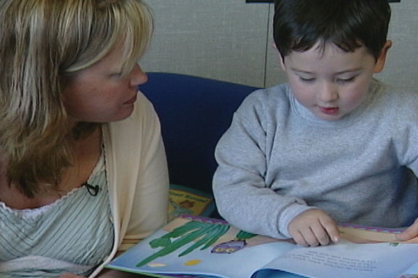A teacher reads to a child.